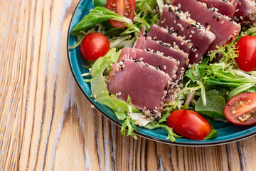 Salad with raw tuna , sesame and cherry tomatoes photography . Top view