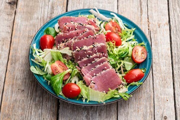 Salad with raw tuna , sesame and cherry tomatoes photography . Top view