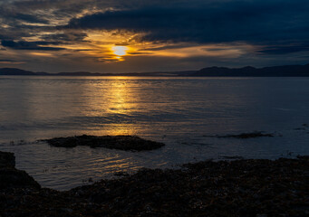 Sunrise over sea with reflected light on calm water 