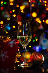 Glass of sparkling wine against Christmas tree lights.