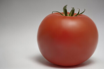 Bright red tomato isolated on white background. One whole fresh tomato
