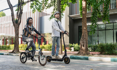 Commuting to work with bicycle. Young business person cycling and riding electric scooter to office in downtown district. Modern diversity people use eco transportation in city. Sustainable lifestyle. © Nassorn