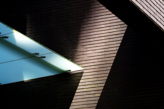 An artistic portrayal of light and shadows interacting with urban architecture, emphasizing shapes and forms that invite viewers to engage with the structure's beauty.