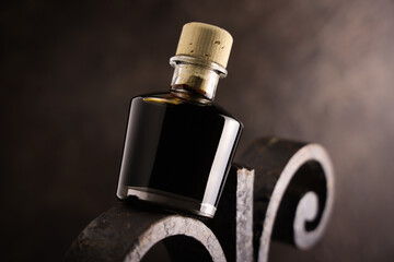 Bottiglietta di aceto balsamico, condimento tipico di Modena, isolata su fondo scuro, primo piano