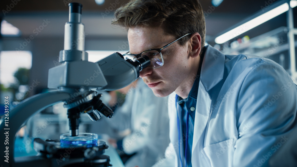 Poster Portrait of a Young Smart Scientist Working in a Laboratory, Using Advanced Microscope, Writing Down Research Data in a Paper Notebook. Caucasian Biotechnology Specialist Using Modern Tools
