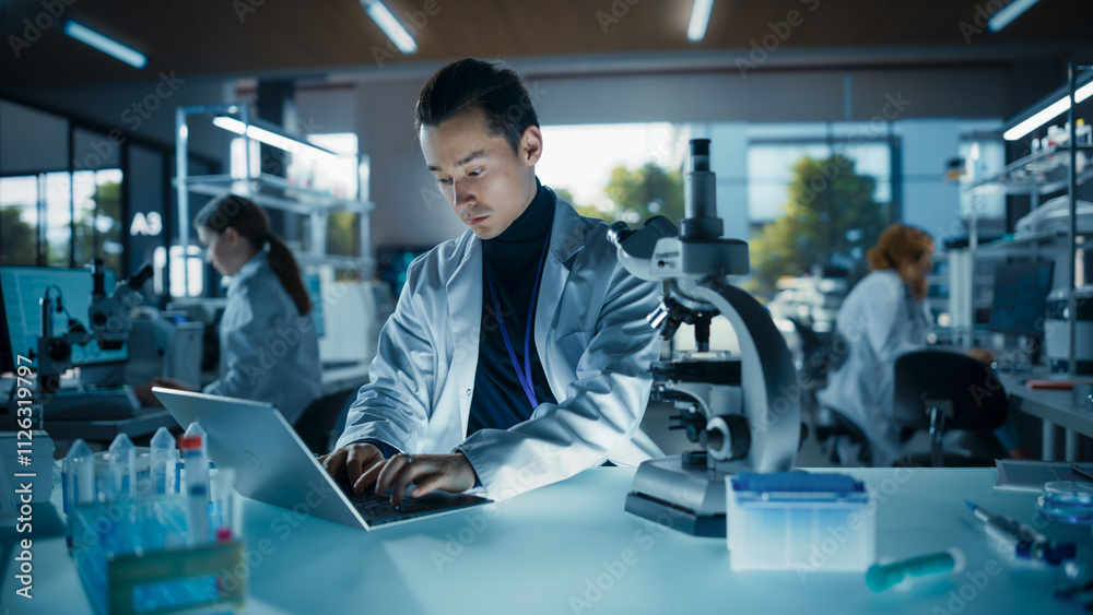 Poster portrait of a young graduate student working in a laboratory, using laptop, writing down research da