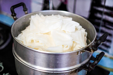 Picture of the chef steaming Wide Rice Noodles in a steamer to make them soft and cooked to perfection.