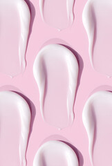 smears of cream texture on pastel pink background