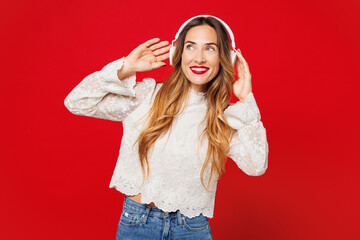 Young smiling happy Caucasian woman she wear white blouse casual clothes listen to music in...