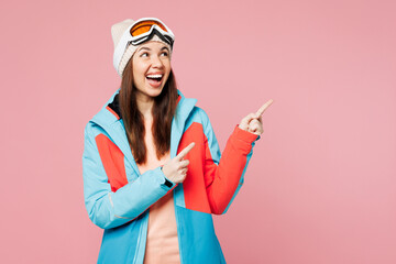 Skier young amazed woman in warm blue padded jacket ski goggles mask spend extreme weekend winter...