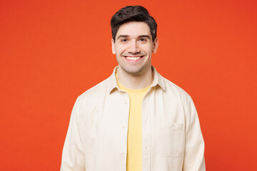 Young smiling happy satisfied positive cheerful man he wears white shirt yellow t-shirt casual clothes looking camera isolated on plain red orange wall background studio portrait. Lifestyle concept.