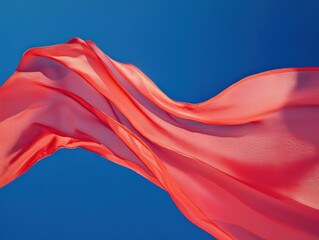 flowing red fabric against a clear blue sky