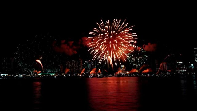 Colorful Fireworks in the city over the river. Colorful bright fireworks on cityscape, count down new year eve celebration.