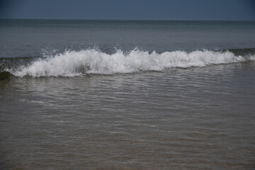 Soft wave of blue ocean on sandy beach.