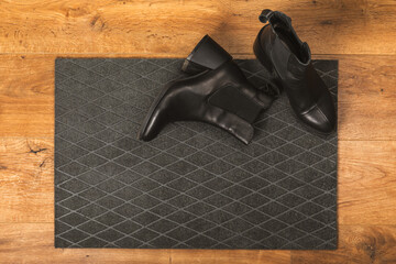 Doormat. Welcome mat on the floor background. Women's shoes on a doormat on background. Interior decor element in the hallway. Close-up. Space for text. Copy space.rug near the door in the hallway.