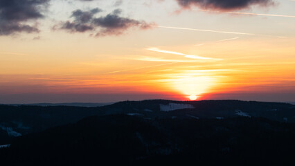 Colorful sunset over the Czech countryside. View from the Teplice-Adršpašské rocks of the Giant Mountains and the surrounding hills.