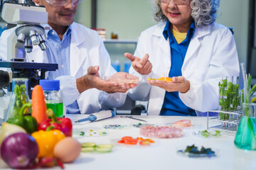 A female and male scientist conduct plant research in a laboratory, using microscopes, petri...