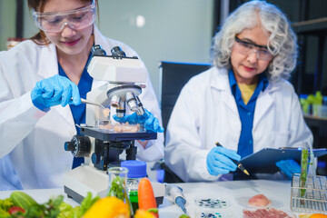 A male scientist and two women conduct plant research in a laboratory.  microscopes, petri...