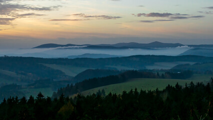 Colorful sunset over the Czech countryside. View from the Teplice-Adršpašské rocks of the Giant Mountains and the surrounding hills.