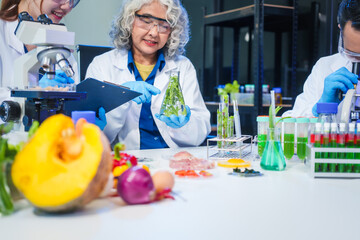 A male scientist and two women conduct plant research in a laboratory.  microscopes, petri dishes,test tubes to analyze genetically modified plants, food, meat, eggs,vegetables for nutritional value