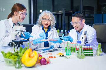A male scientist and two women conduct plant research in a laboratory.  microscopes, petri dishes,test tubes to analyze genetically modified plants, food, meat, eggs,vegetables for nutritional value