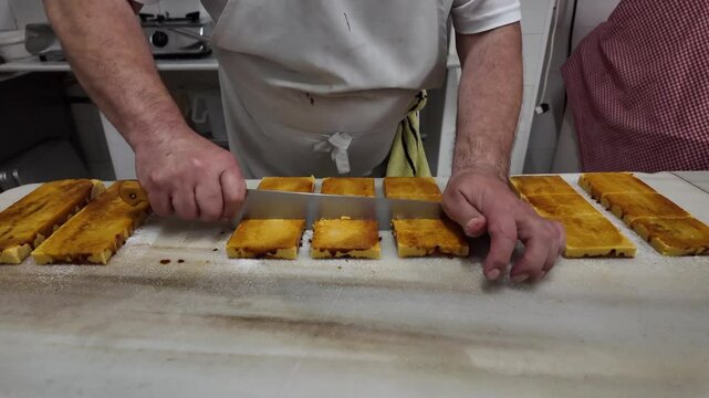 Hands of a white pastry chef in his traditional workshop preparing homemade turron for Chistmas, a traditional Spanish sweet.