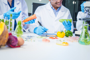 A male scientist and two women conduct plant research in a laboratory.  microscopes, petri dishes,test tubes to analyze genetically modified plants, food, meat, eggs,vegetables for nutritional value