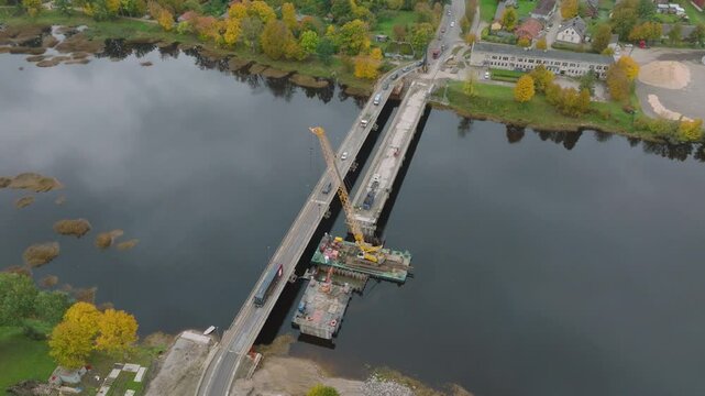 Bridge cross aerial top down panorama, cranes working between Latvia and Estonia (Salacgriva city, Salaca river)