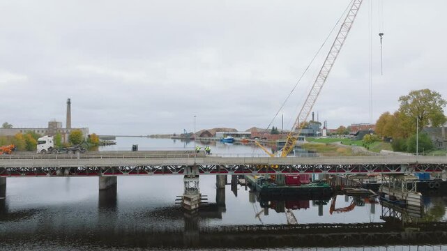 Panoramic view of Salacgriva city bridge construction crossing a Salaca river at Industrial city, aerial landscape