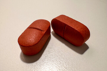 Two Red Pills on a White Surface