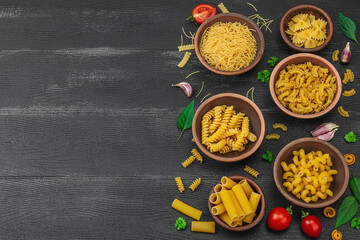 Pasta. Various kinds of uncooked pasta and noodles over wooden background. Traditional Italian