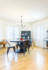 Dining area featuring a round table and modern decor in a bright, sunny space with stylish furniture
