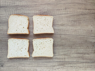 Square pieces of white toast bread on a wooden background	