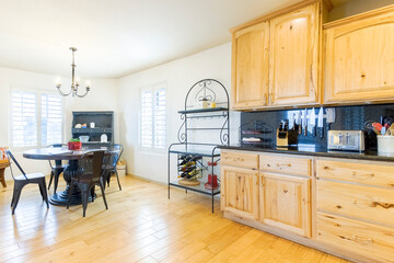 Charming kitchen interior with wooden cabinets and dining area featuring a round table and black chairs