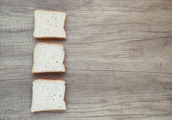 Square pieces of white toast bread on a wooden background	