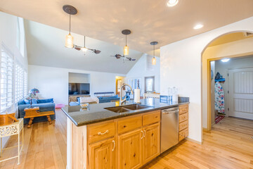 Modern open-concept kitchen with wooden accents and spacious living area in bright home setting