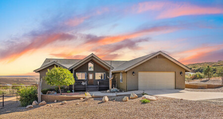 Beautiful home at sunset with colorful sky and calm landscape in the background