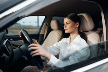 Driver, woman, steering wheel, car a woman sits confidently in the driver's seat of a car, her hands gripping the steering wheel, and her gaze directed towards the camera