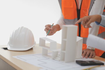 Construction and structure concept of Engineer or architect meeting for project working with partner and engineering tools on model building and blueprint in working site, contract for both companies.