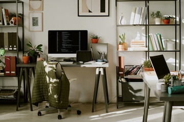 Empty office with work desks, digital devices and book shelves