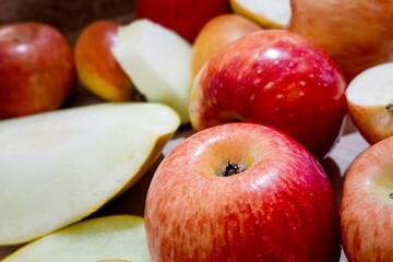 Ripe red apples and ripe melon lie in a heap on the table.