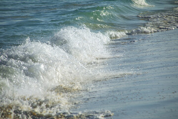 Close-up of surf on sandy beach
