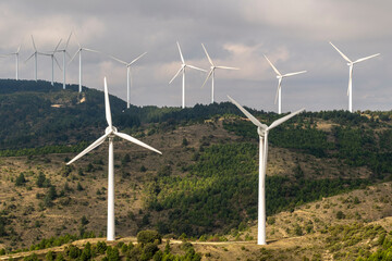 A collective of wind turbines strategically placed on green terrain, showcasing the importance of renewable energy while harmonizing beautifully with the landscape environment in Navarra Spain