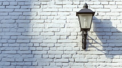 Vintage street lamp on textured white brick wall casting shadows in urban setting