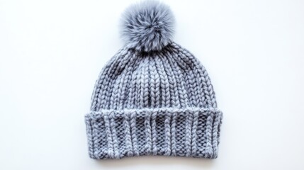 Fototapeta premium Knit gray hat with pom pom on white backdrop showcasing winter fashion accessory for warmth and style