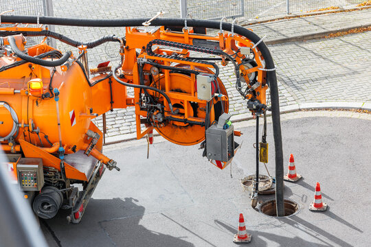 Pipe hose sewage truck car engine emptying city street sewerage manhole. Septic cleaning vacuum service maintenance technology equipment industry. Suction vehicle cleaner machine pumping drainage