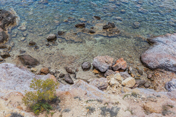 Serene View Of Greece's Rocky Shoreline With Crystal-clear Water, Capturing Summer's Peaceful Coastal Beauty