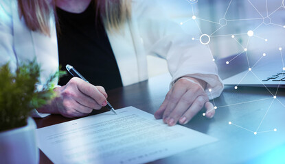 Hand of businesswoman signing a document (lorem ipsum text used); light effect