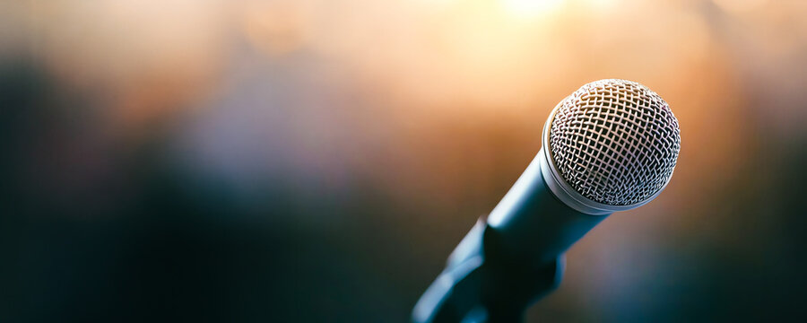 Close-up of a microphone with a blurred background, capturing the essence of live performance and public speaking.