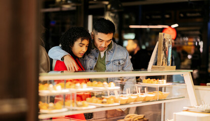 Multiracial couple choosing appetizers at market on valentine's day